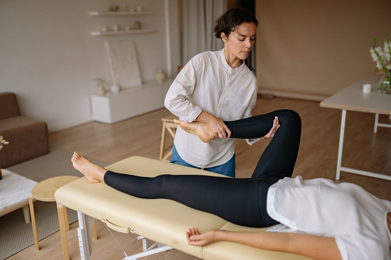 services-04 A massage therapist provides a rejuvenating leg treatment in a calming spa environment.