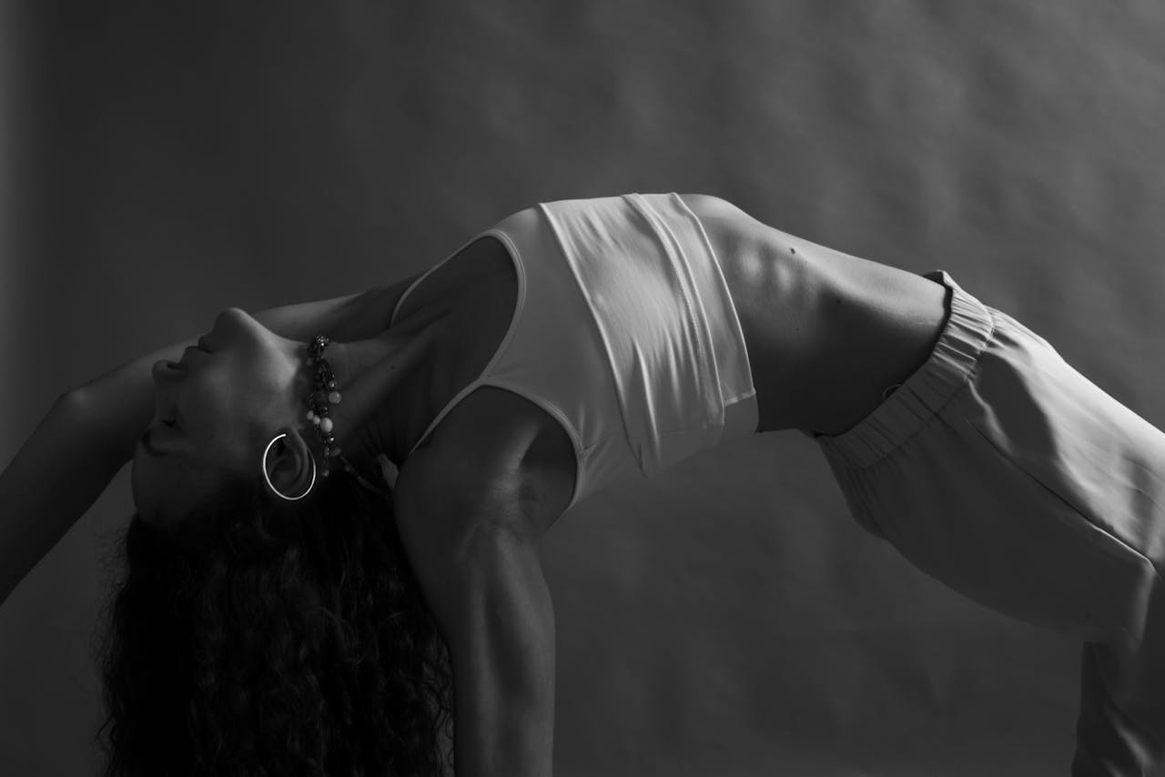 mission-img Monochrome image of a woman practicing yoga in a studio setting, emphasizing mindfulness and wellness.